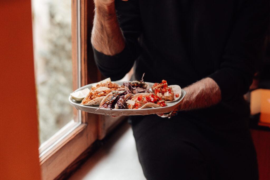 Man holding plate of tacos