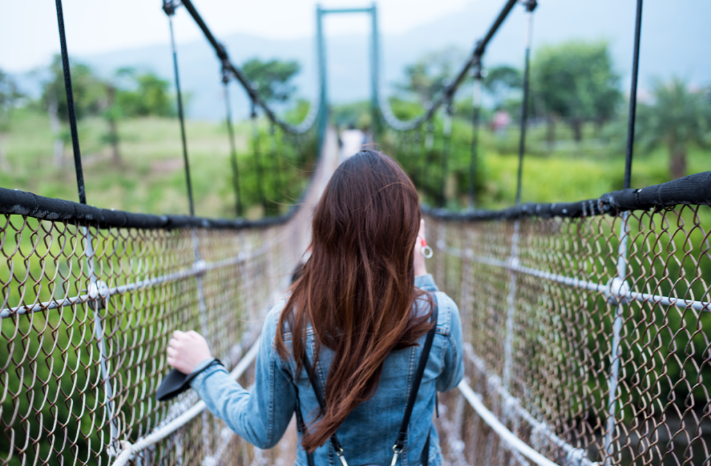 Woman walking on a swing bridge